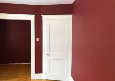 Red interior wall painting with white trim in Dubai